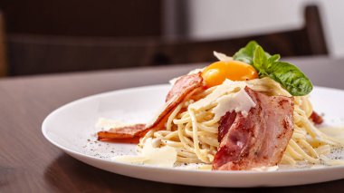 Kızarmış domuz pastırması ile İtalyan makarna spagetti carbonara parmesan peynir ve yumurta sarısı. Restoran tabloda bu. Kopya alanı, seçici odak