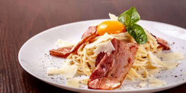 Kızarmış domuz pastırması ile İtalyan makarna spagetti carbonara parmesan peynir ve yumurta sarısı. Restoran tabloda bu. Kopya alanı, seçici odak
