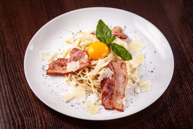 Kızarmış domuz pastırması ile İtalyan makarna spagetti carbonara parmesan peynir ve yumurta sarısı. Restoran tabloda bu. Kopya alanı, seçici odak