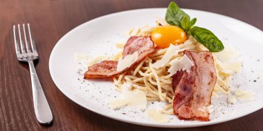 Kızarmış domuz pastırması ile İtalyan makarna spagetti carbonara parmesan peynir ve yumurta sarısı. Restoran tabloda bu. Kopya alanı, seçici odak
