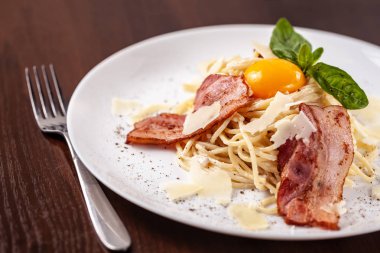 Kızarmış domuz pastırması ile İtalyan makarna spagetti carbonara parmesan peynir ve yumurta sarısı. Restoran tabloda bu. Kopya alanı, seçici odak