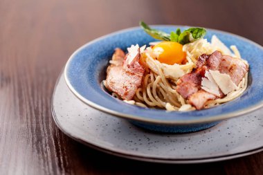 Kızarmış domuz pastırması ile İtalyan makarna spagetti carbonara parmesan peynir ve yumurta sarısı. Restoran tabloda bu. Kopya alanı, seçici odak