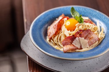 Kızarmış domuz pastırması ile İtalyan makarna spagetti carbonara parmesan peynir ve yumurta sarısı. Restoran tabloda bu. Kopya alanı, seçici odak