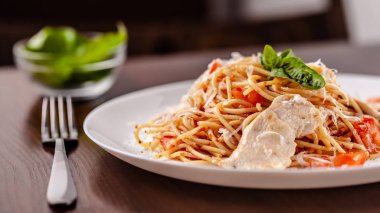 İtalyan makarna spagetti kırmızı domates sosu, domates ve ızgara tavuk. Restoran tabloda bu. Kopya alanı, seçici odak