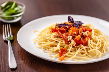 İtalyan makarna spagetti kırmızı domates sosu, domates ve ızgara tavuk. Restoran tabloda bu. Kopya alanı, seçici odak