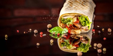 İki burrito, siyah ve beyaz lavaş tavuk, mantar, salata, domates, limon ve salsa. Kopya alanı, seçici odak