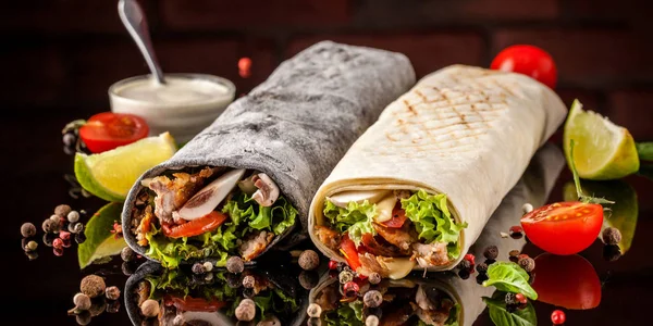 İki burrito, siyah ve beyaz lavaş tavuk, mantar, salata, domates, limon ve salsa. Kopya alanı, seçici odak
