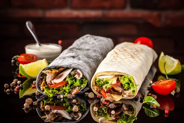 İki burrito, siyah ve beyaz lavaş tavuk, mantar, salata, domates, limon ve salsa. Kopya alanı, seçici odak