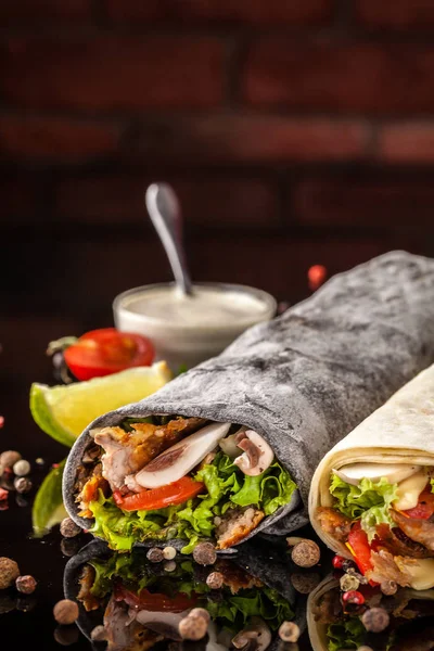 İki burrito, siyah ve beyaz lavaş tavuk, mantar, salata, domates, limon ve salsa. Kopya alanı, seçici odak