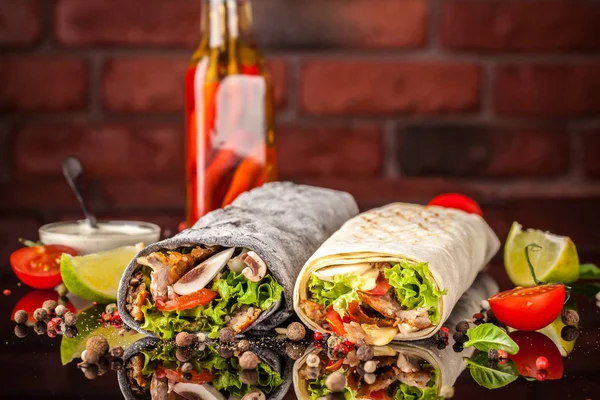 İki burrito, siyah ve beyaz lavaş tavuk, mantar, salata, domates, limon ve salsa. Kopya alanı, seçici odak