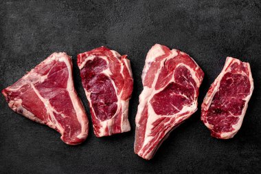 Et çiğ biftek siyah bir arka plan üzerinde yatıyor. yan görünüm, kopya alanı, üstten görünüm
