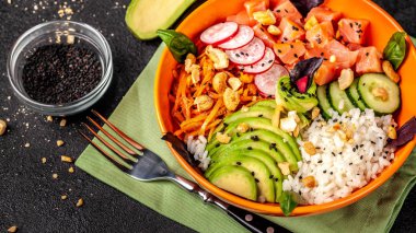 Hawaiian salata somon balık, avokado, Kore havuç, salatalık, turp ve pirinç siyah susam ile Poke. turuncu bir tabak içinde. Siyah arka plan üzerine. kopya alanı, üstten görünüm
