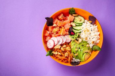 Hawaiian salata somon balık, avokado, Kore havuç, salatalık, turp ve pirinç siyah susam ile Poke. turuncu bir tabak içinde. 2018 mor eğilim arka plan üzerinde. kopya alanı, üstten görünüm