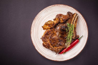 Sulu domuz Biftek soslu bir plaka seramik siyah bir arka plan üzerinde kırmızı biber ile büyük bir parçası. yan görünüm, kopya alanı, üstten görünüm