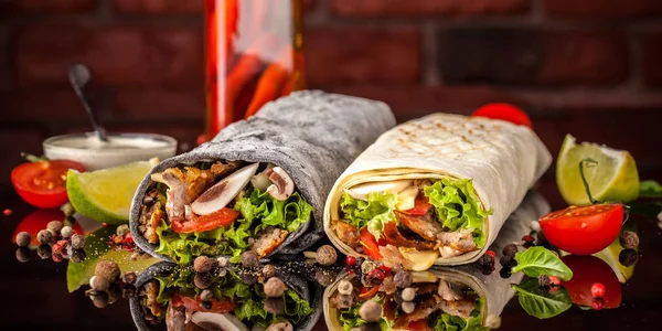 İki burrito, siyah ve beyaz lavaş tavuk, mantar, salata, domates, limon ve salsa. Kopya alanı, seçici odak