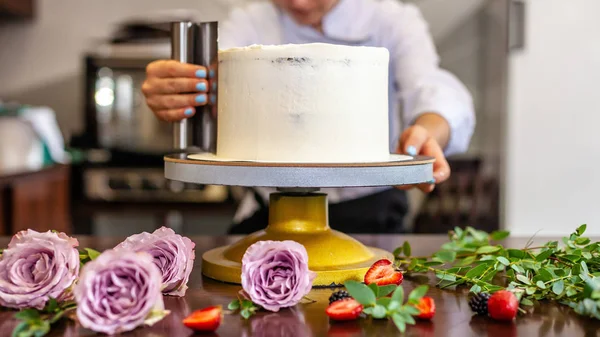 The chef's confectioner cooks a cake and decorates it with fresh flowers. background image.