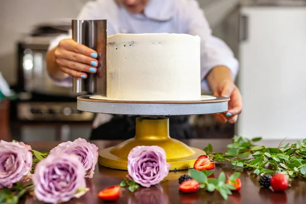 The chef\'s confectioner cooks a cake and decorates it with fresh flowers. background image.