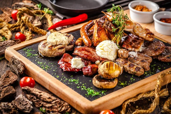 Arap mutfağı Dubai. Soslu bir ahşap tahta üzerinde bir ızgara üzerinde çeşitli kızarmış sosis. Restoranda güzel bir hizmet bir kavramdır. Arka plan resmi.