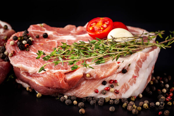 The concept of ecological pure meat, eco product. Marble pork tenderloin, raw meat on a black background with spices. side view, copy space