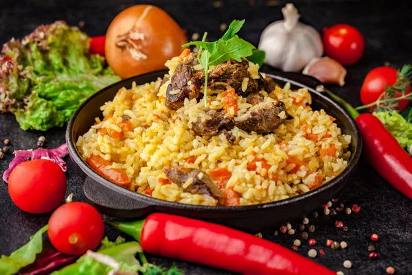Özbek Oryantal mutfağı. Bir dökme demir tavada pilavı kuzu yaptı. yanında sebze siyah bir tablo. seçici odak