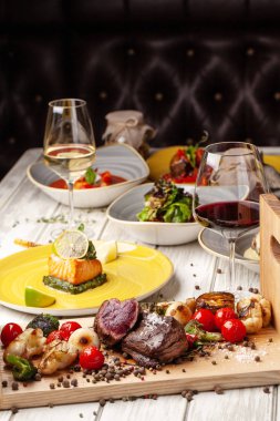Orta pişmiş, ahşap bir tahta üzerinde ızgara sebzeli iki sulu biftek ile kızarmış. Hava Fritözler ile pişirilir. Akşam yemeği akşam koydu tabloda restoran tatil veya Doğum günü için. seçici odak