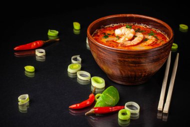 Asya mutfağının kavramı. Japonca veya Çince miso çorbası ile deniz ürünleri, karides ve pırasa ile. siyah bir zemin üzerine Çin sopa yanında. Kopya alanı