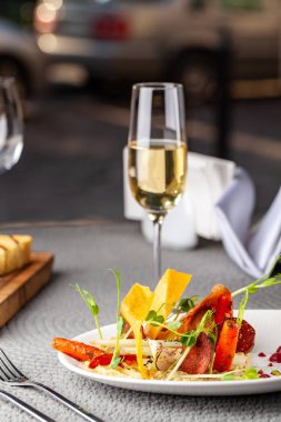 Yüksek Avrupa mutfağı, moleküler mutfağı kavramı. Sebze bahçesinden pahalı bir restoranda yemek. Tablo Araçları ve bir kadeh şampanya pahalı tablo sunucuda.