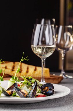 Yüksek Avrupa mutfağı, moleküler mutfağı kavramı. Midye sebze ile deniz ürünleri ile çanağı. Server tablo, tablo aletleri ve bir kadeh şarap