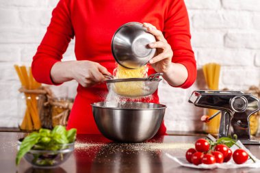 Adım adım. El ile işlem yapma Fettuccine makarna çeşitleri. Ev makarna makarna üreticisi ile. Un, semola di grano duro, yumurta, domates, fesleğen yalan ahşap bir masa üzerine. Tarifi.