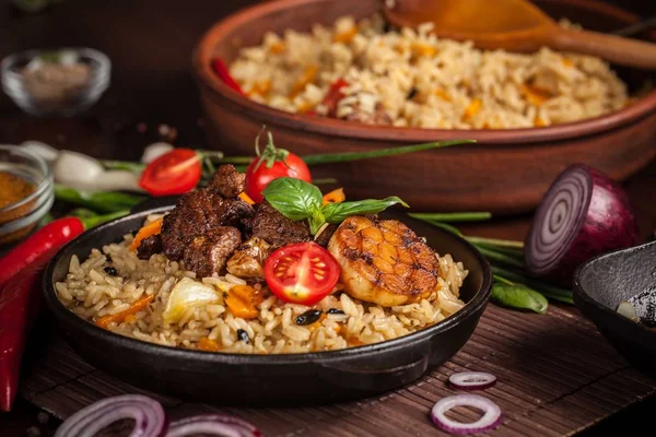 Doğu mutfağı kavramı. Ev yapımı özbek pilavı kuzu üzerinden dökme demir tencere içinde servis. Kopya alanı.