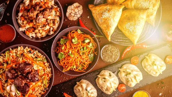 Assorted Uzbek food set, pilaf, samsa, lagman, manta and Korean carrots, Uzbek restaurant concept, Uzbek food feast. Festive, homemade lunch, dinner for the whole family. copy space, top view — Stock Image Assorted Uzbek Food Set Pilaf Samsa Lagman Manta Korean Carrots Stock Image