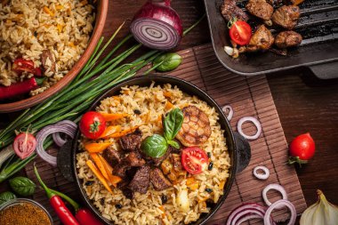 Doğu mutfağı kavramı. Ev yapımı özbek pilavı kuzu üzerinden dökme demir tencere içinde servis. Kopya alanı.