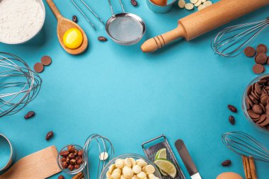 Pişirme genel kavram ya da pişirme arka plan çerçeve. Malzemeler, kek pişirme için mutfak öğeleri. Mutfak eşyaları, un, yumurta, tarçın, beyaz, süt ve siyah çikolata. Metin alanı, üstten görünüm.