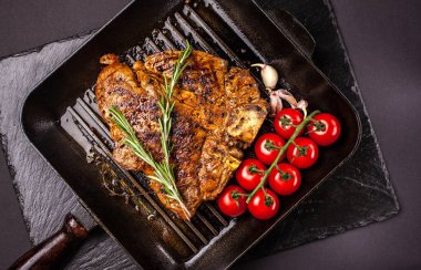 Kızarmış parça et, sığır eti biftek, domuz eti veya dana eti, kuzu, bir siyah ızgara tava, siyah mazisi yatıyor. Yanında et baharatlar ve sebzeler vardır. Üstten görünüm. Kopya alanı