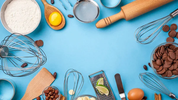 Pişirme genel kavram ya da pişirme arka plan çerçeve. Malzemeler, kek pişirme için mutfak öğeleri. Mutfak eşyaları, un, yumurta, tarçın, beyaz, süt ve siyah çikolata. Metin alanı, üstten görünüm.