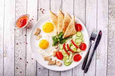 Mutfağı İngilizce, sahanda yumurta, sebze ve salata Tavuk, kızarmış ekmek tost ile beyaz bir tabakta servis kahvaltı. Kopya alanı, seçici odak