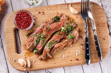 Meksika yemeği. Kız eti biftek filetosu baharatlı yeşil salsa ilavesi ile yaptı. bir ahşap tahta üzerinde et. Bıçak ve çatal elinde. kavramı bir restoranda güzel bir tabak. seçici odak