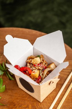 Sokak gıda kavramı. Çin Japon tavuk ve sebze tek kullanımlık kağıt mutfak eşyaları ile erişte. Kopya alanı, seçici odak