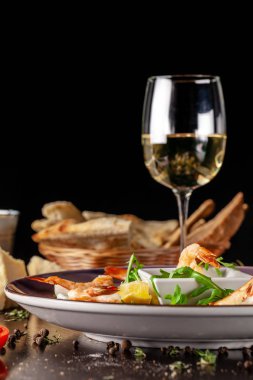 İtalyan mutfağı kavramı. Kaplan karides pirinç fişleri bir kremalı sos. Limon ve roka salatası. Bir bardak kırmızı şarap geçerli. güzel restoranda garson