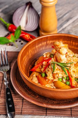 İspanya mutfağı kavramı. Paella deniz ürünleri ve karides, bir kil plaka yeşil bezelye ile. Bir kadeh iyi şarap tablodur.