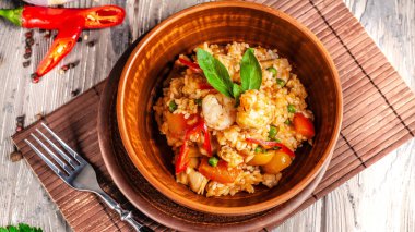 İspanya mutfağı kavramı. Paella deniz ürünleri ve karides, bir kil plaka yeşil bezelye ile. Bir kadeh iyi şarap tablodur.