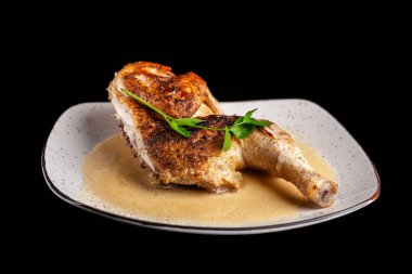 Gürcü mutfağı kavramı. Sarımsak soslu siyah bir zemin üzerine beyaz bir tabakta gevrek kabuk ile yarım pişmiş tavuk.