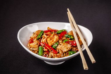 Asya mutfağı kavramı. Buğday noodle durum un tavuk ve sebze ile üzerinden. Havuç, biber, yeşil fasulye, beyaz ve siyah susam. Japonca veya Çince yemek.