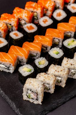 Japon ve Çin mutfağından kavramı. Suşi ve rulo yalan bir taş tahtaya ayarlayın. Arka plan resmi.