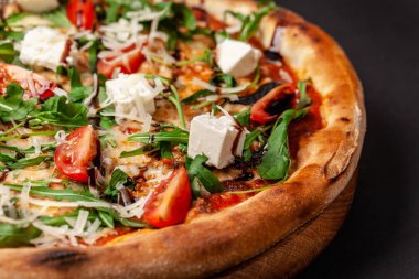 İtalyan mutfağı kavramı. Büyük iki tarafında siyah bir arka plan ile gerçek İtalyan pizza ince bir pastayı. Yakın çekim. Arka plan resmi.