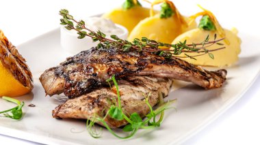 Sulu ızgara uskumru, patates püresi, limon ve tartar sos ile servis edilir. Microgreen. Beyaz bir tarekle modern sahada. Beyaz bir arka plan üzerinde. güzel restoranda garson.