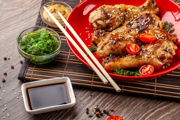 Japon ve Çin mutfağından kavramı. Bacaklar acı biber, susam, chuka salata, ahşap masa üzerinde Çince bezelye ile kızarmış tavuk. Asya yemek. üstten görünüm, düz yatıyordu