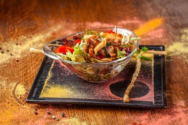 Hint mutfağı kavramı. Sığır eti ve tavuk, biber ve tatlı nane sosu ile sıcak salata. Bir cam levha bir restoranda yemekler hizmet. Ahşap bir masaya. arka plan resmi.