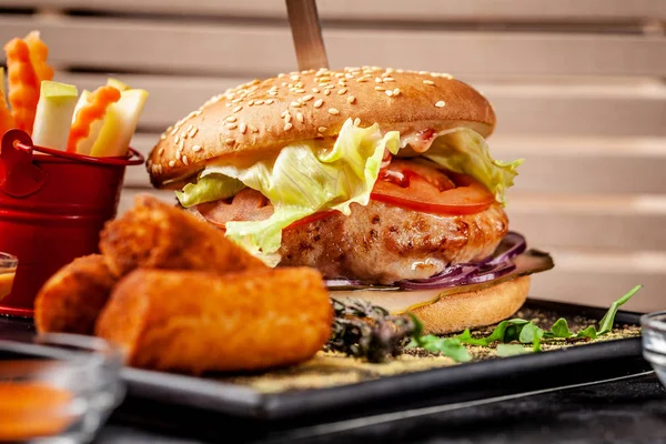 The concept of modern Indian cuisine 2019. Fresh burger made from soy patties, with vegetables and salad, with potato crunch and fresh vegetables. Indian spices. copy space