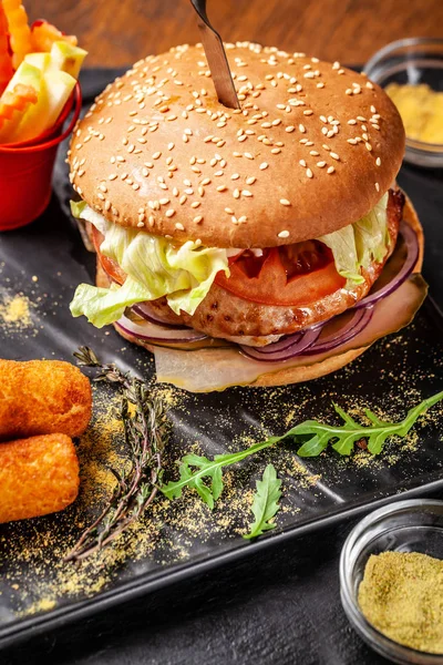 The concept of modern Indian cuisine 2019. Fresh burger made from soy patties, with vegetables and salad, with potato crunch and fresh vegetables. Indian spices. copy space